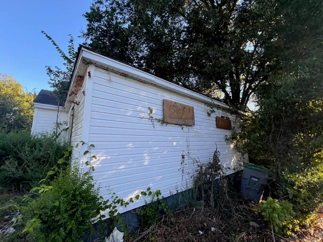 a view of a wooden house with a yard and plants