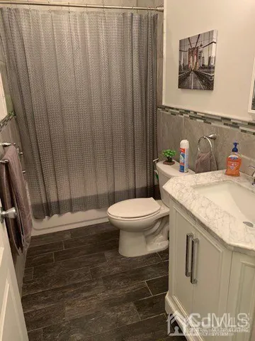 a bathroom with a granite countertop toilet sink and mirror