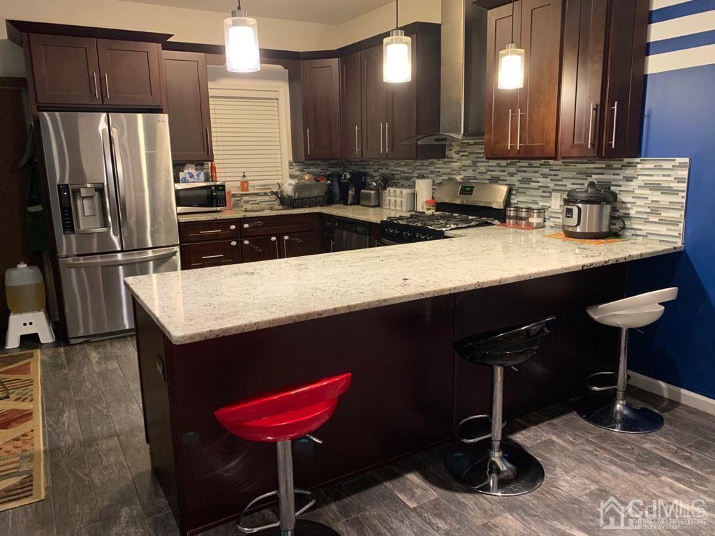 58 Christopher Street Carteret, NJ 07008 - Photo 5 of 20 a kitchen with a refrigerator a sink and chairs