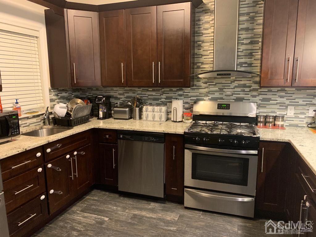 58 Christopher Street Carteret, NJ 07008 - Photo 6 of 20 a kitchen with stainless steel appliances granite countertop wooden cabinets and a stove top oven