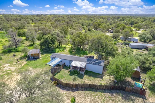 an aerial view of a house with a yard and lake view