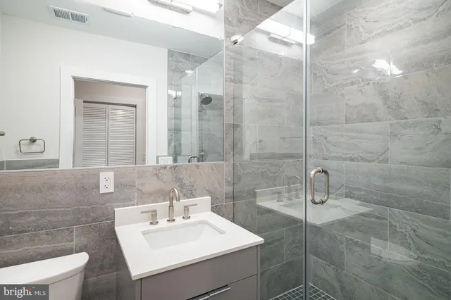 a bathroom with a sink mirror and toilet