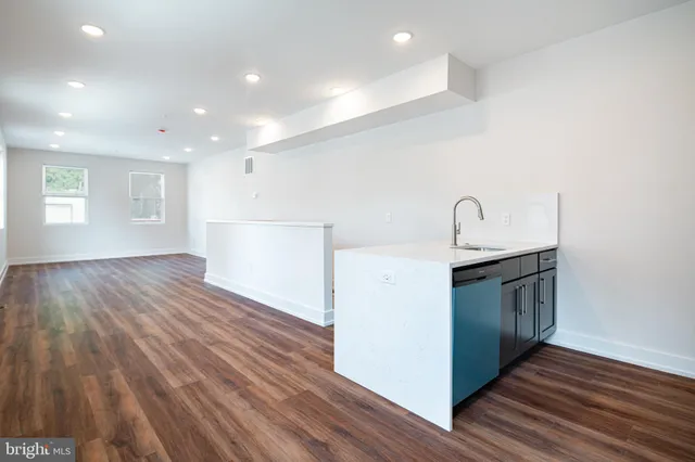 a kitchen view with wooden floor and electronic appliances