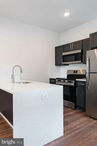 a kitchen with a refrigerator and a stove top oven