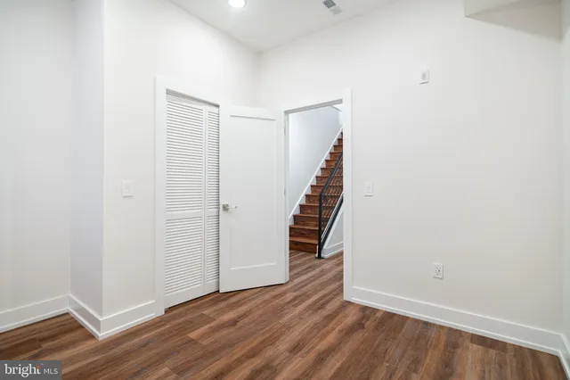 a view of an empty room with wooden floor and entryway