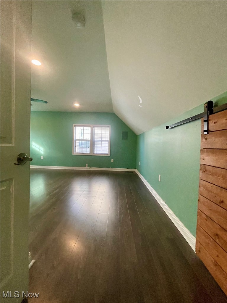1544 Edgefield Road Lyndhurst, OH 44124 - Photo 25 of 36 Additional living space with a barn door, vaulted ceiling, and dark wood finished floors