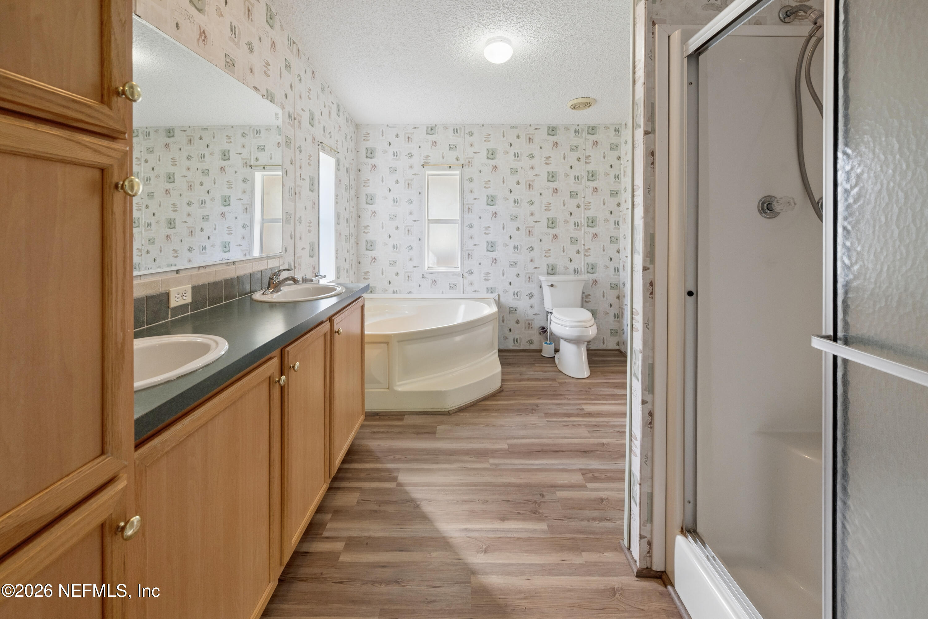 3112 Southeast 120th Street Starke, FL 32091 - Photo 13 of 30 a bathroom with a granite countertop double vanity sink a mirror and a bathtub