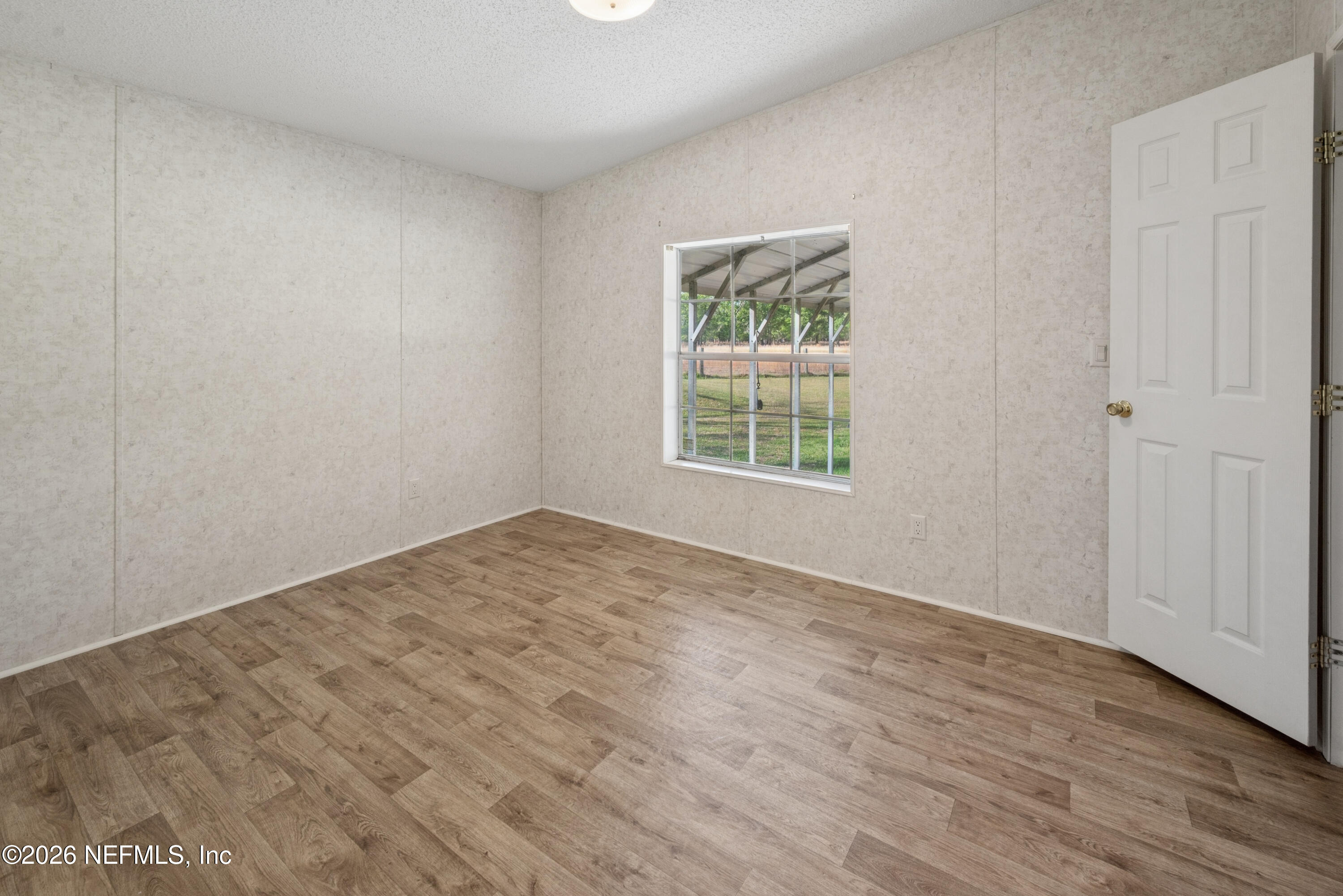 3112 Southeast 120th Street Starke, FL 32091 - Photo 15 of 30 an empty room with wooden floor and windows