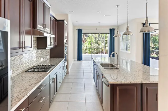 a view of an empty room with window and chandelier fan