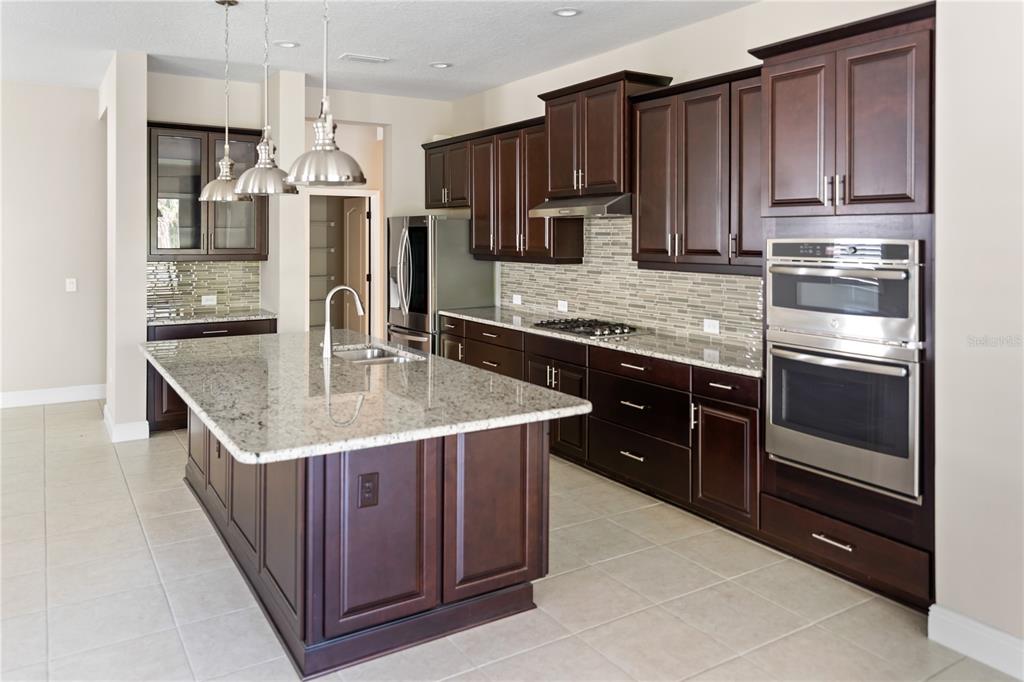 13017 Steinhatchee Loop Venice, FL 34293 - Photo 14 of 98 a kitchen with stainless steel appliances granite countertop a sink a stove and a refrigerator