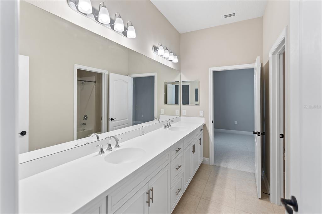 13017 Steinhatchee Loop Venice, FL 34293 - Photo 34 of 98 a bathroom with a double vanity sink and a mirror