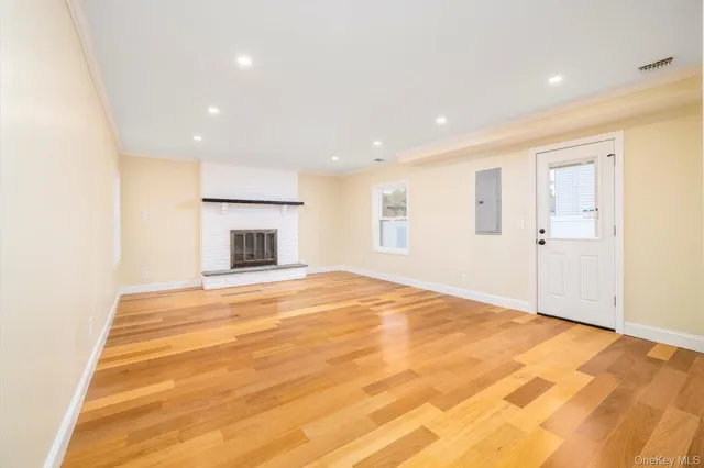 a view of empty room with wooden floor and fireplace