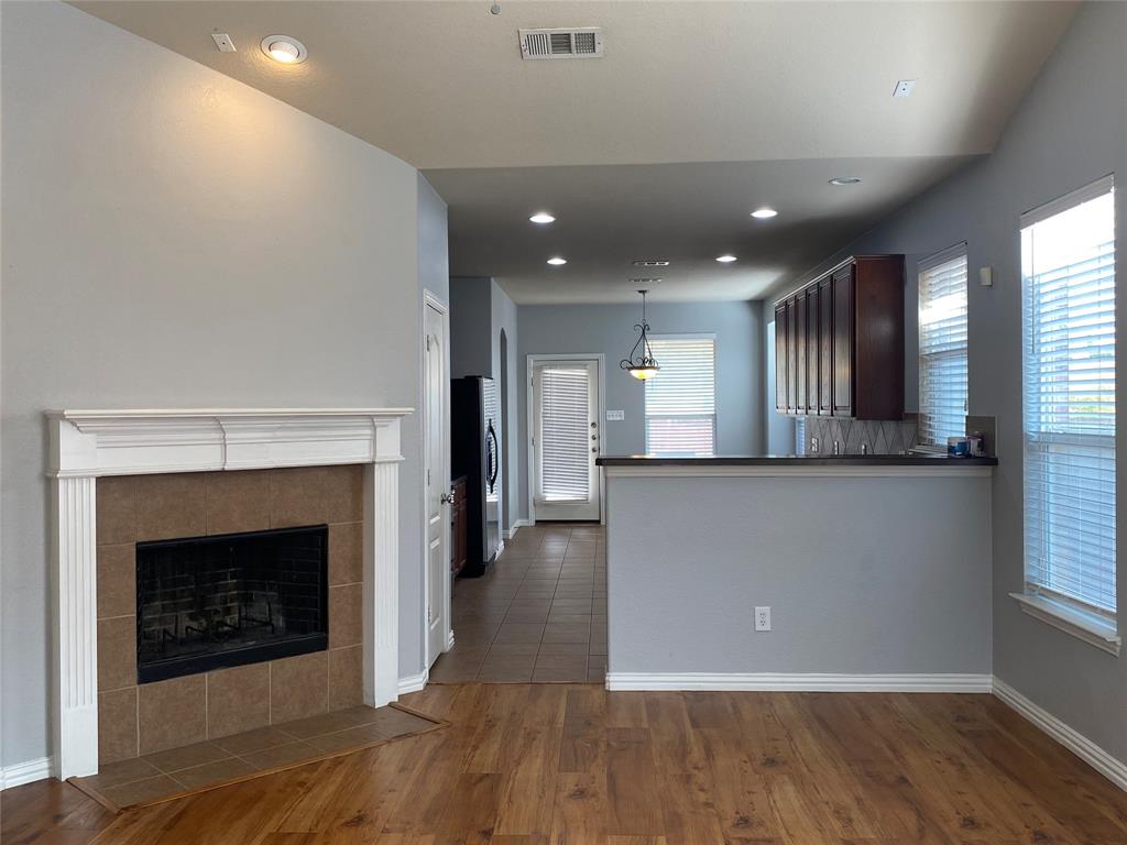 1708 Adams Place Prosper, TX 75078 - Photo 3 of 13 a view of a kitchen with a fireplace and wooden floor