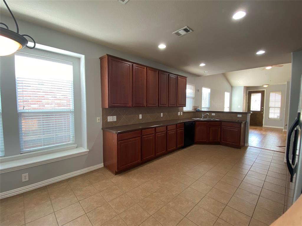1708 Adams Place Prosper, TX 75078 - Photo 4 of 13 a large kitchen with stainless steel appliances granite countertop a granite counter tops and a window