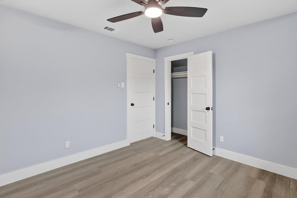2005 Chestnut Road Carrollton, TX 75007 - Photo 17 of 35 an empty room with wooden floor and ceiling fan