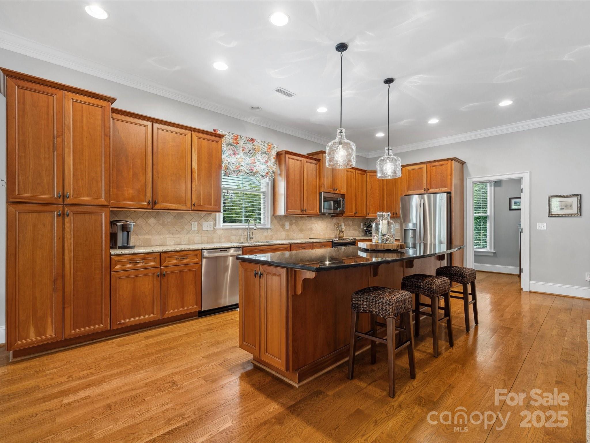 894 Stratford Run Drive Fort Mill, SC 29708 - Photo 13 of 45 a kitchen with stainless steel appliances granite countertop wooden cabinets a stove a sink and a refrigerator