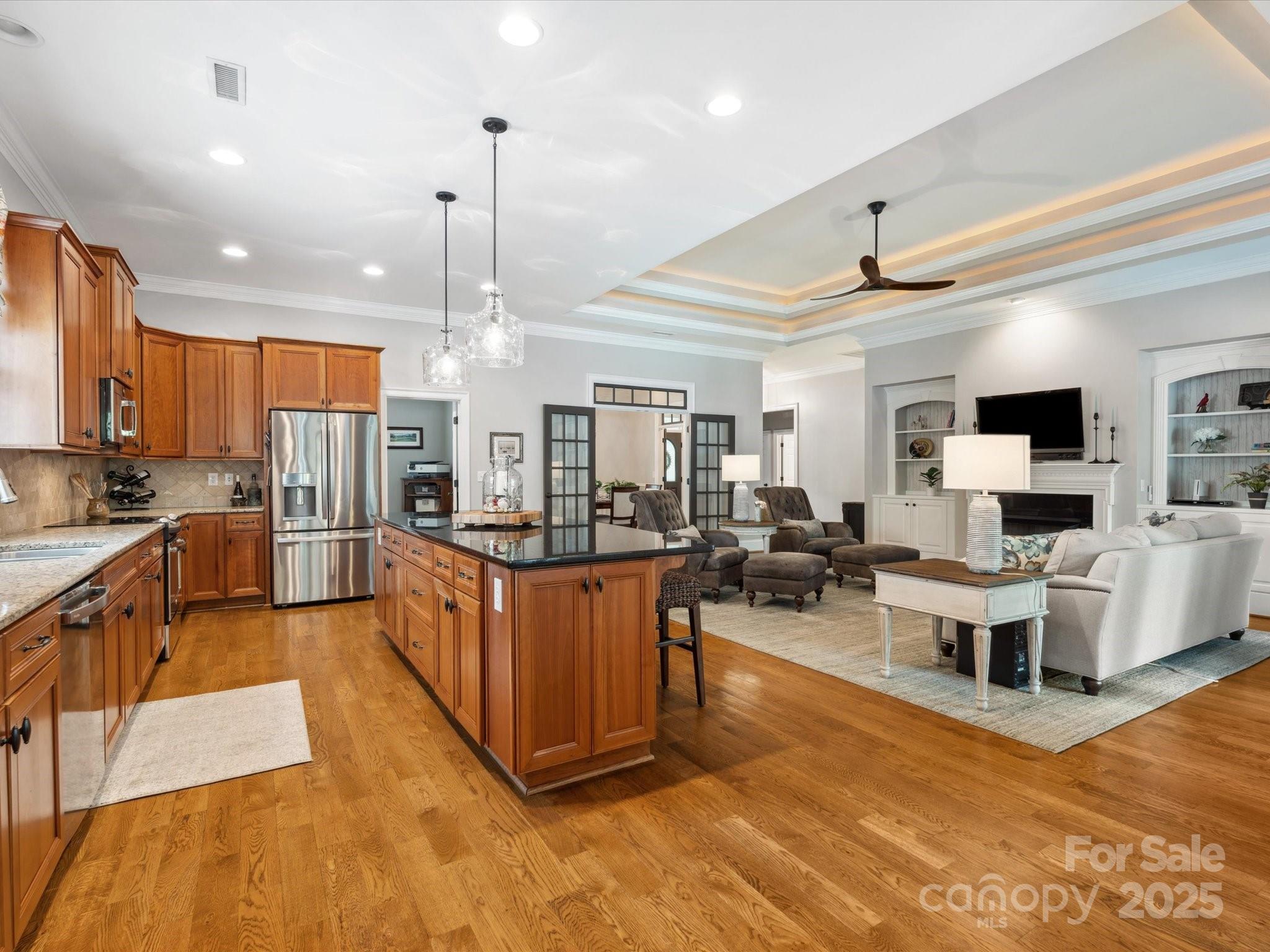 894 Stratford Run Drive Fort Mill, SC 29708 - Photo 15 of 45 a large kitchen with stainless steel appliances kitchen island granite countertop a large kitchen island a couch and a view of living room