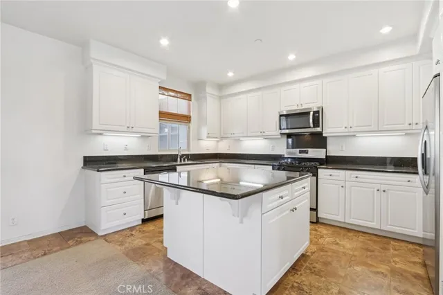 a kitchen with stainless steel appliances granite countertop a sink and cabinets