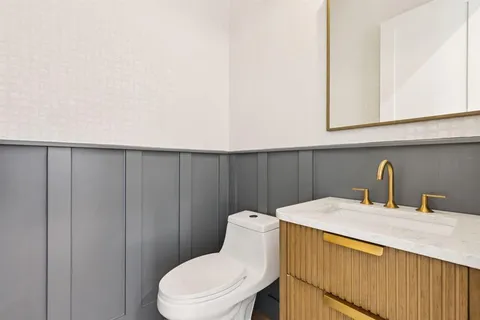 a bathroom with a sink a toilet and mirror