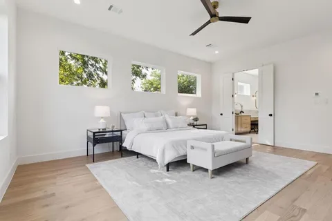 a spacious bedroom with a bed a couch and a window