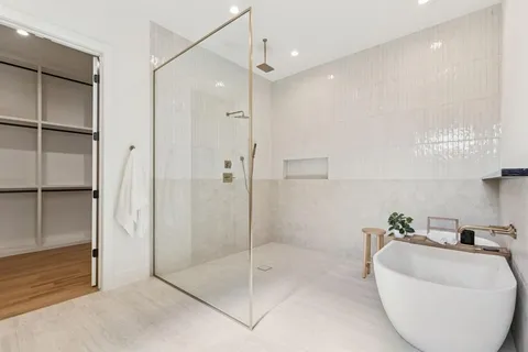 a spacious bathroom with a glass shower door and a sink