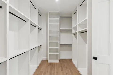 a view of walk in closet with empty racks