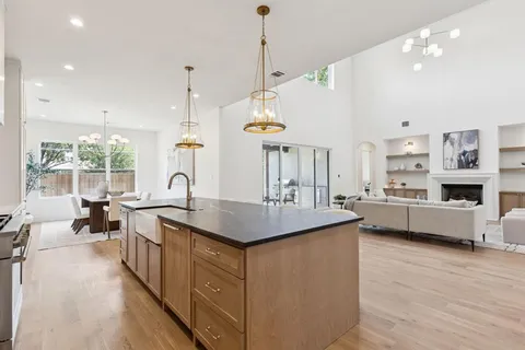 a kitchen with cabinets a sink a counter top space and living room view