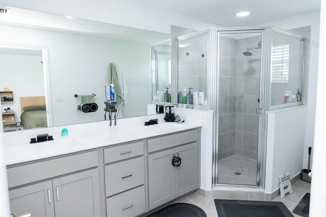 a bathroom with a shower sink and mirror