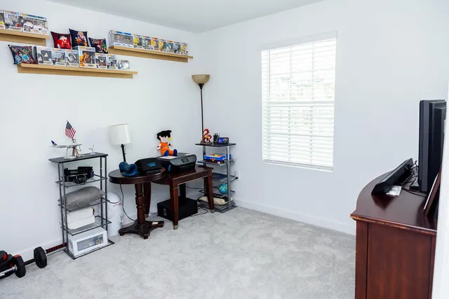 a work room with furniture a rug and a window