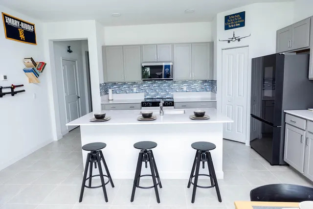a kitchen with stainless steel appliances a refrigerator and a stove top oven