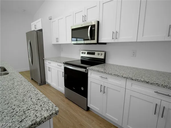 a kitchen with stainless steel appliances granite countertop a stove a sink and a refrigerator
