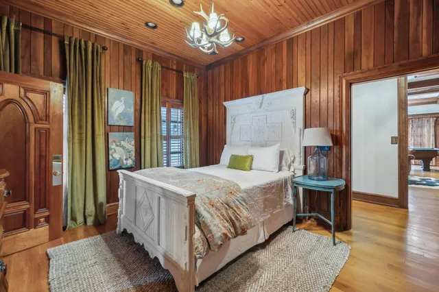 a kitchen with stainless steel appliances kitchen island a table chairs in it and wooden floors