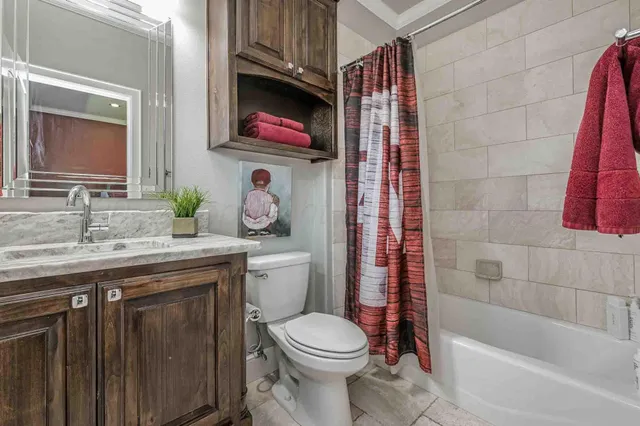 a bathroom with a granite countertop toilet sink and mirror