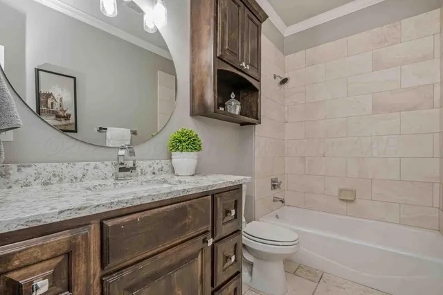 a bathroom with a granite countertop sink a toilet and bathtub