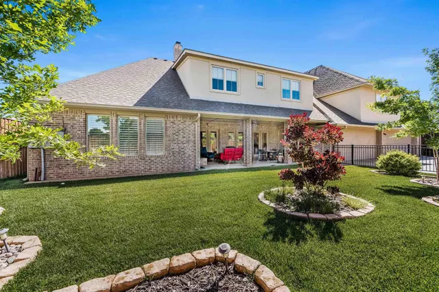 a front view of a house with a yard garden and outdoor seating