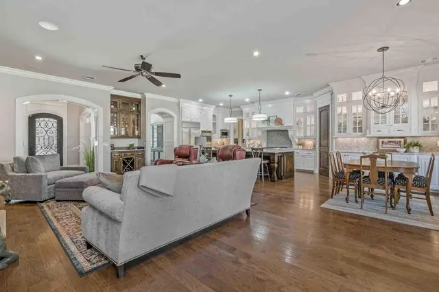 a living room with furniture a dining table and a chandelier