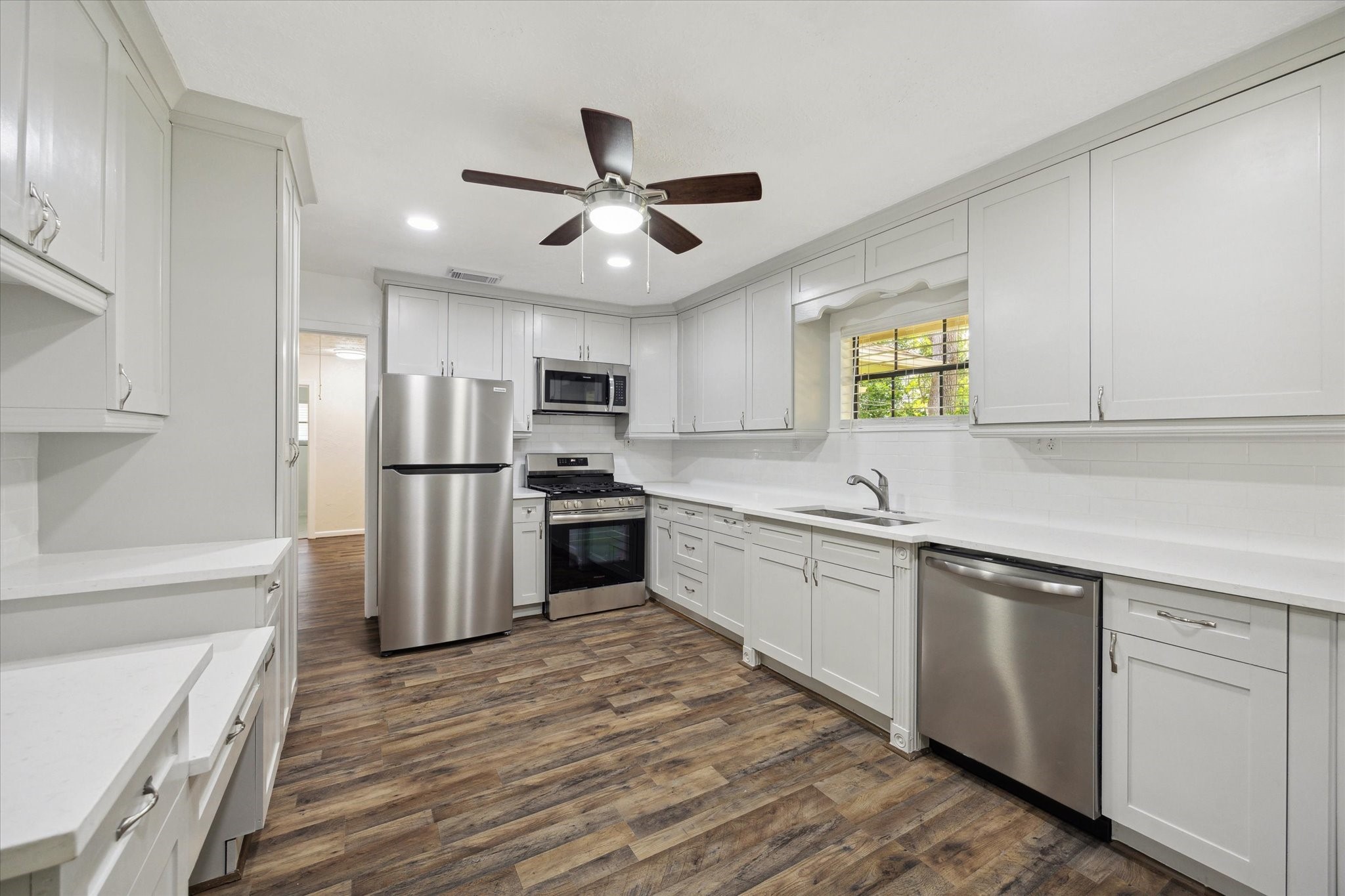 1309 Centennial Drive Houston, TX 77055 - Photo 13 of 33 a kitchen with white cabinets and white appliances