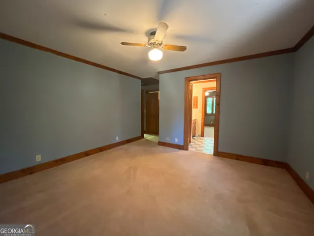 an empty room with windows and fan