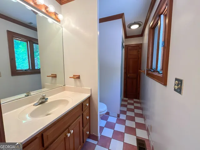a bathroom with a sink a toilet a mirror and shower