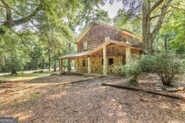 a view of a yard in front of a house with large trees