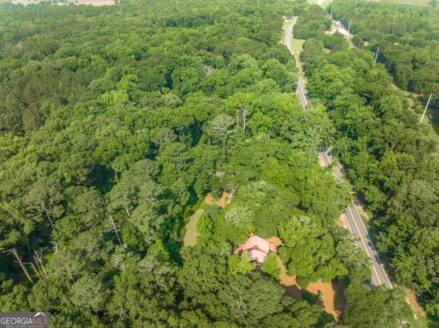 an aerial view of residential houses with outdoor space and trees