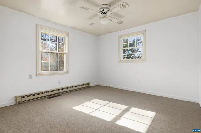 an empty room with windows and ceiling fan
