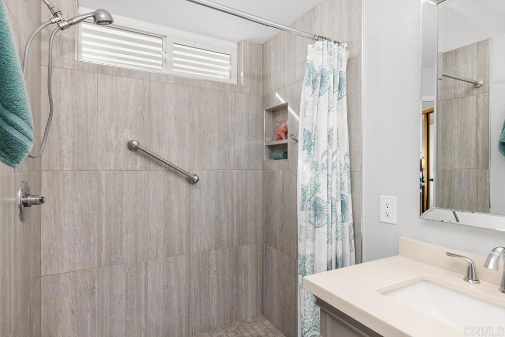 6833 Watercourse Drive Carlsbad, CA 92011 - Photo 15 of 49 a bathroom with a sink and a mirror