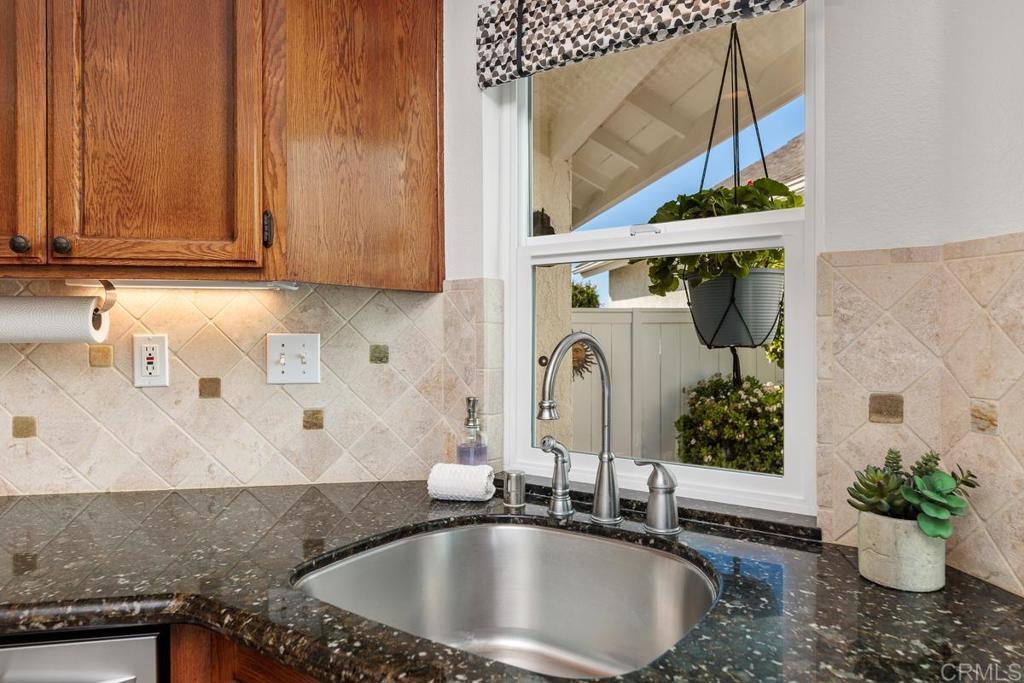 6833 Watercourse Drive Carlsbad, CA 92011 - Photo 27 of 49 a bathroom with a granite countertop sink and a mirror