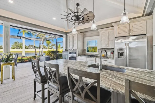 a view of a dining room with furniture a kitchen and chandelier