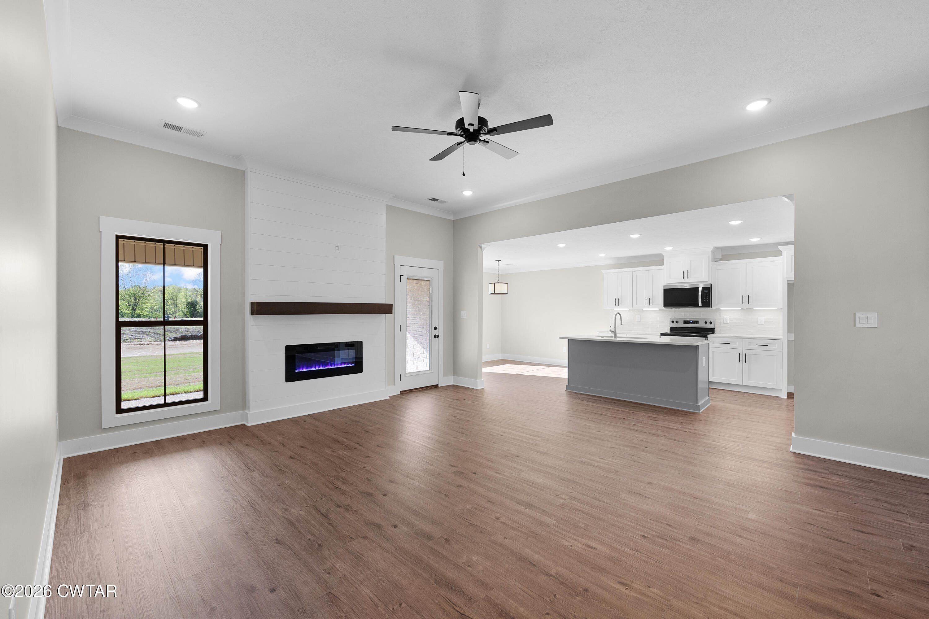 19 Emerald Downs Three Way, TN 38343 - Photo 4 of 17 a view of an empty room with a kitchen and a fireplace