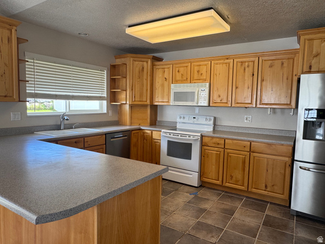 88 Canterbury Lane Logan, UT 84321 - Photo 12 of 37 Kitchen featuring natural wood cabinetry, gray countertops, and tiled flooring
