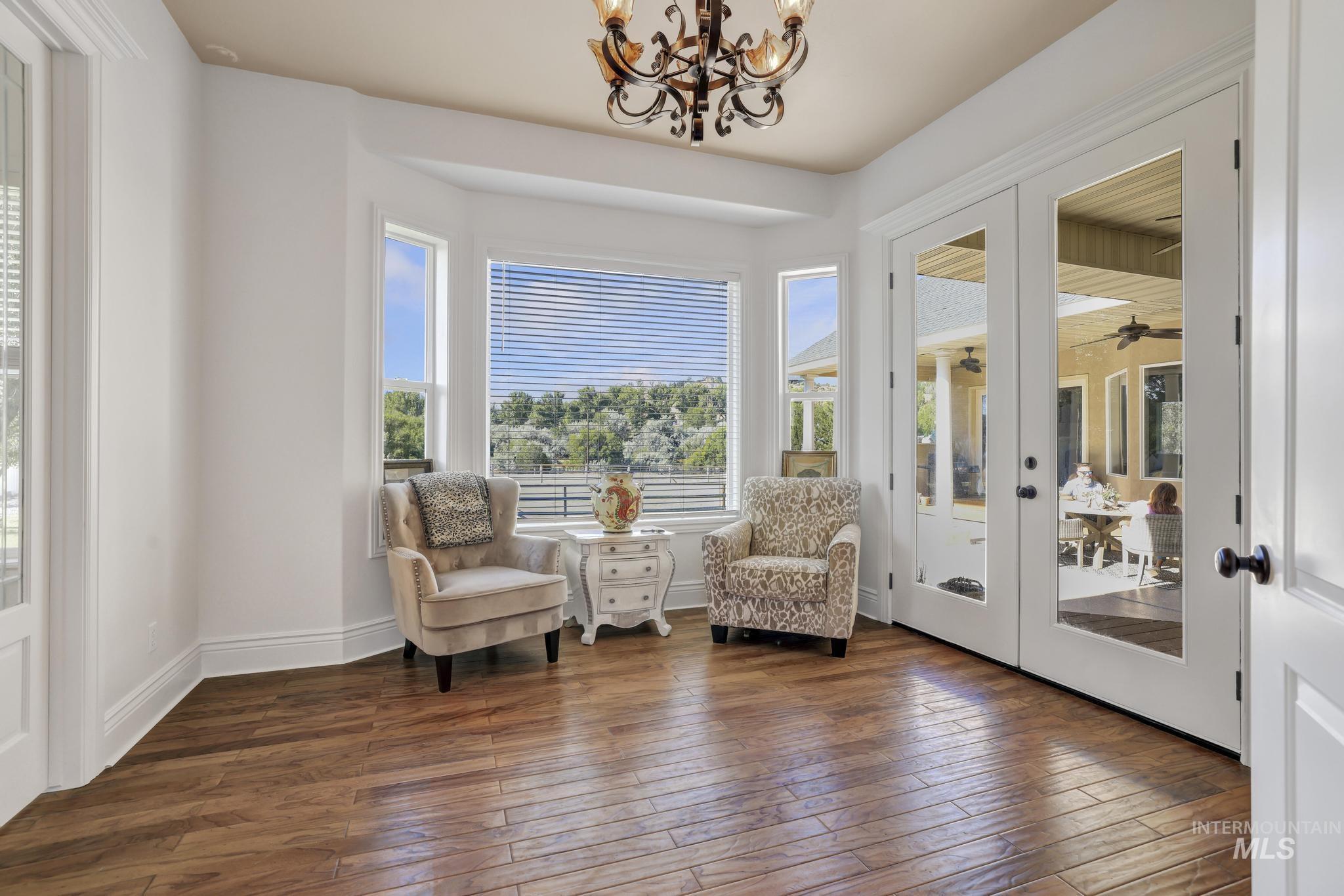 1301 Kanaka Rapids Road Buhl, ID 83316 - Photo 15 of 50 Room featuring wood-finish flooring, a bay window with natural scenery, and a wrought iron chandelier