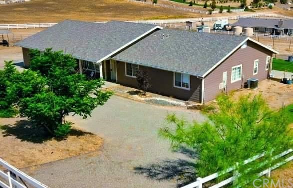 an aerial view of house with yard and trees in the background