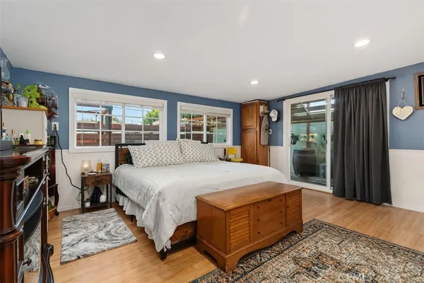 a spacious bedroom with a bed a table and large windows